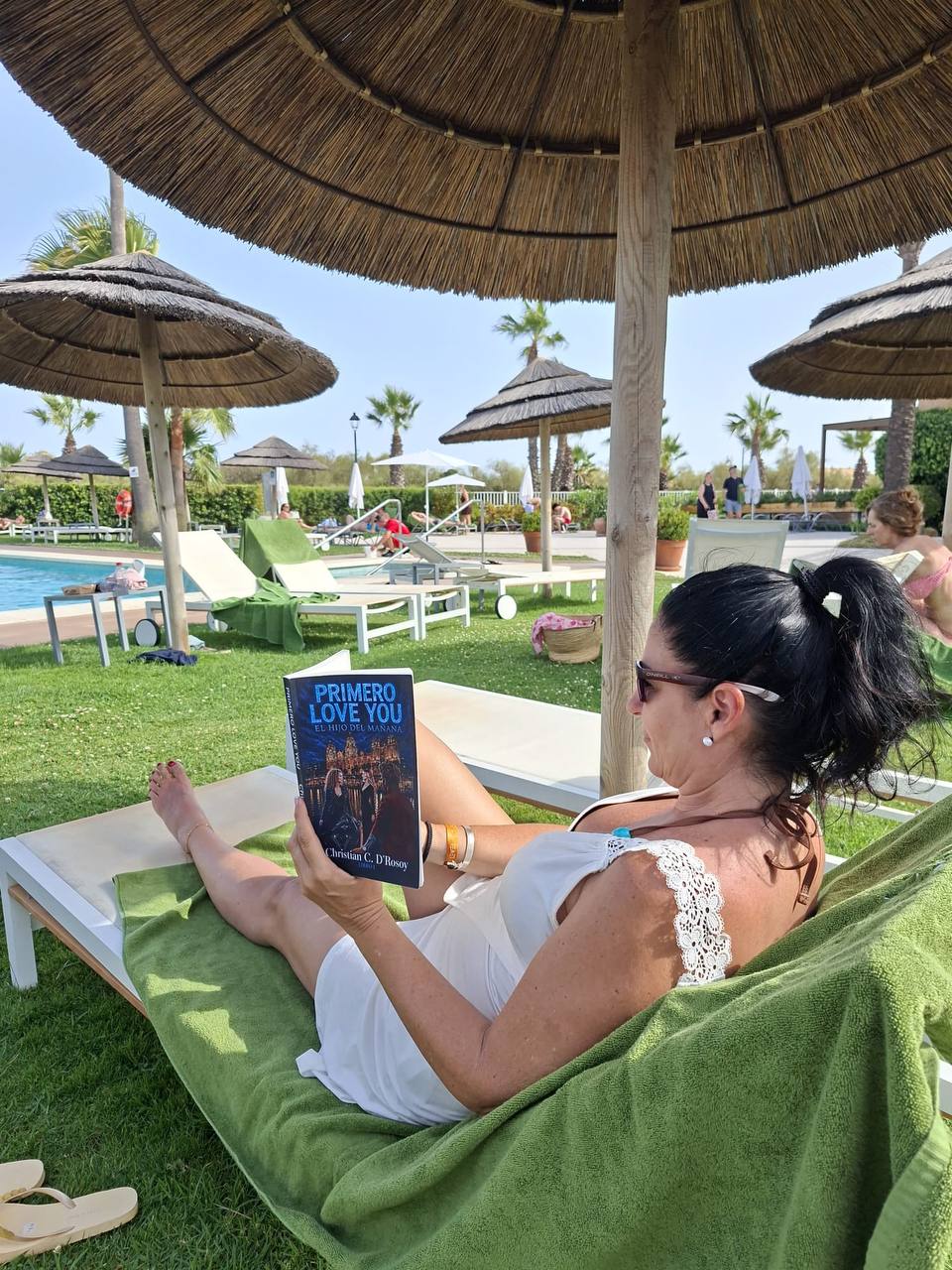 Isa leyendo PRIMERO LOVE YOU junto a la piscina